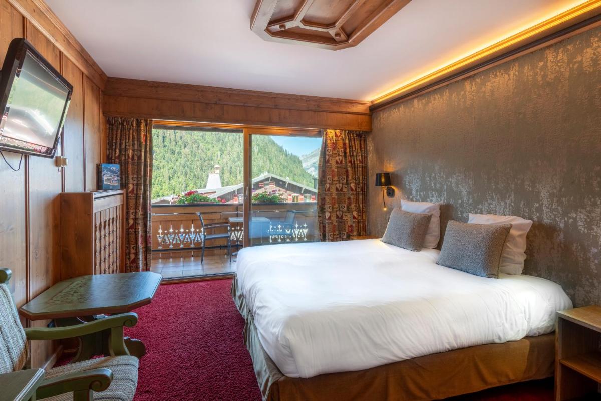 une chambre d'hôtel avec un lit et un balcon dans l'établissement Hôtel Macchi Restaurant & Spa, à Châtel