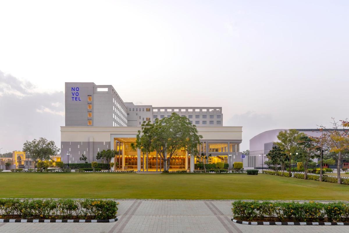 a large building with a park in front of it at Novotel Jaipur Convention Centre in Jaipur