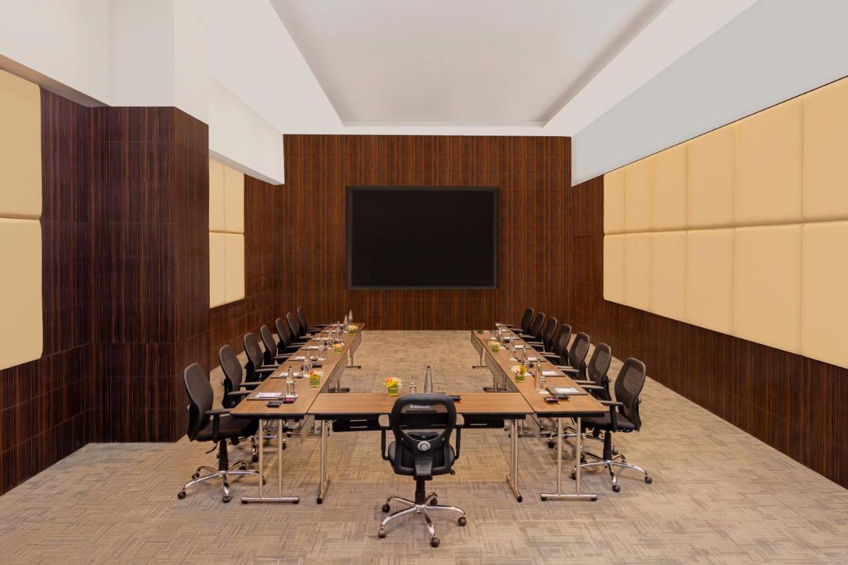 a large conference room with a long table and chairs at Novotel Jaipur Convention Centre in Jaipur