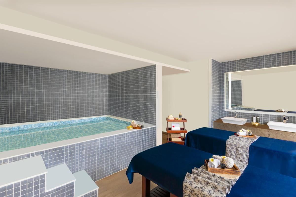 a pool in a room with blue tiles at Novotel Jaipur Convention Centre in Jaipur