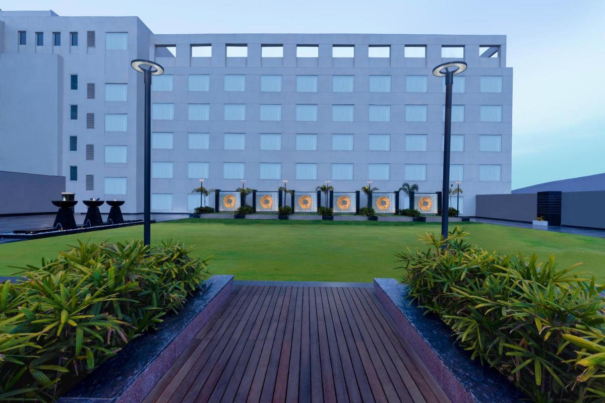 a large building with a lawn in front of it at Novotel Jaipur Convention Centre in Jaipur