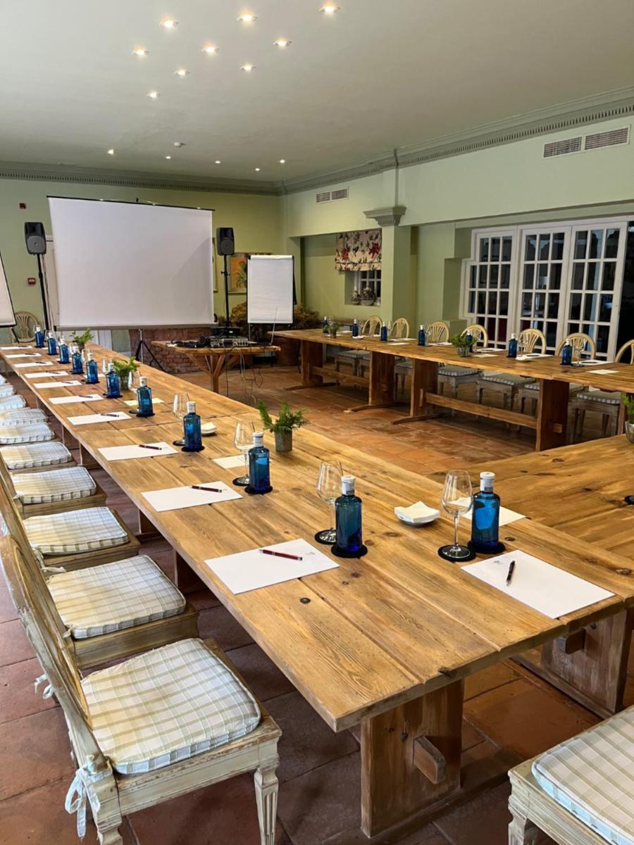 una larga mesa de madera en una gran habitación con bancos en Hotel Valdepalacios Gourmand 5* GL, en Torrico 55 fotos más
