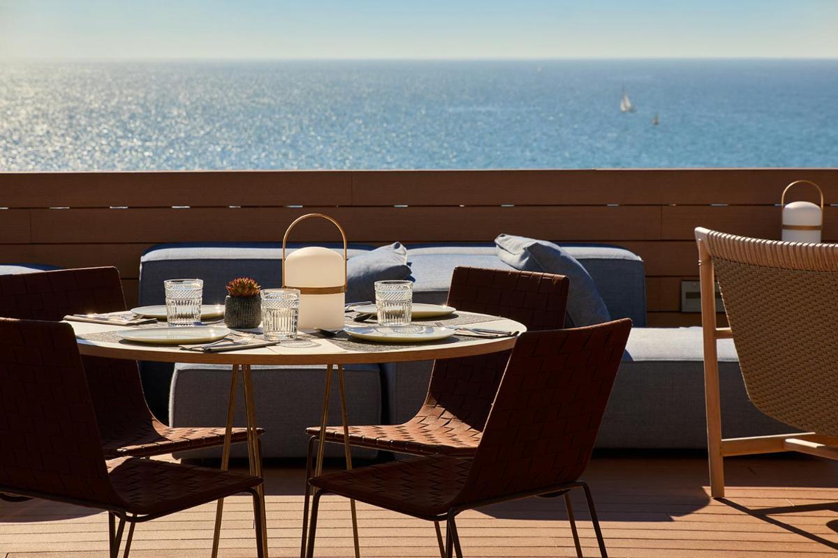 Una mesa y sillas en un balcón con vista al mar. en Hotel Calatrava, en Palma de Mallorca