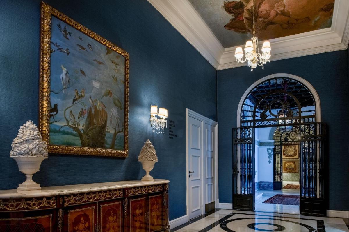 un pasillo con una pared azul con un cuadro y un espejo en Hotel Palacio del Retiro, Autograph Collection, en Madrid 82 fotos más