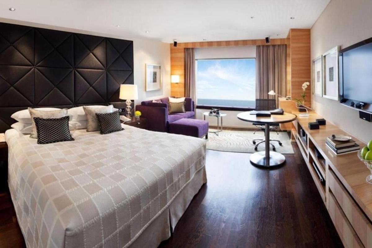 a bedroom with a large bed and a living room at Taj Lands End in Mumbai a bedroom with a large bed and a living room at Taj Lands End in Mumbai