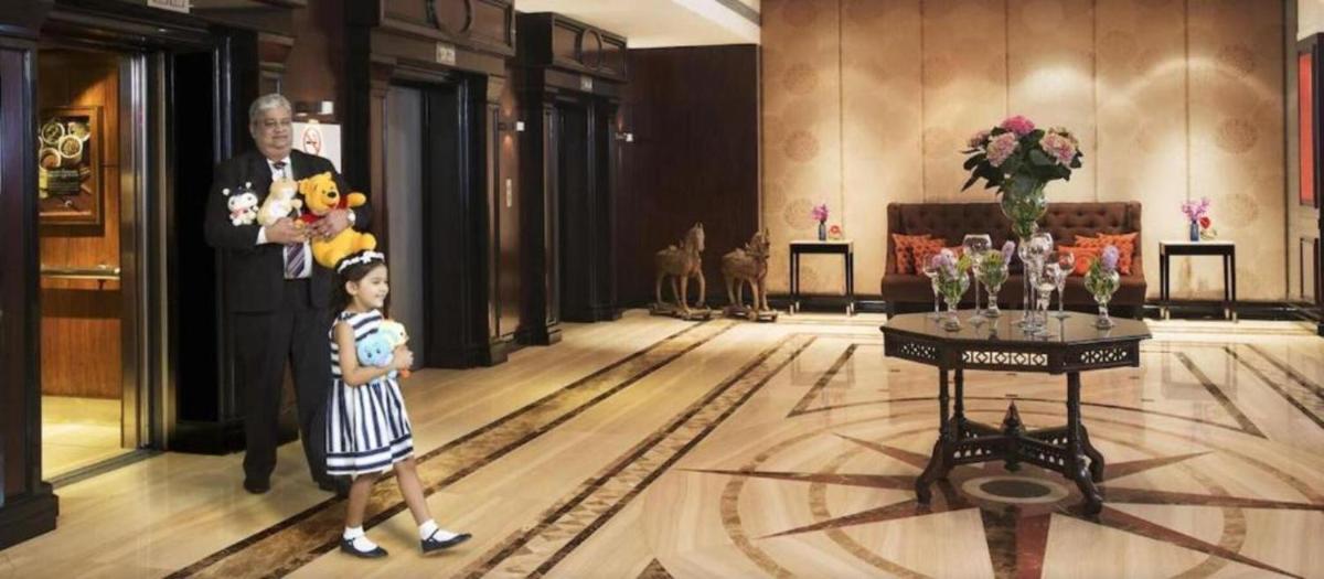 a man and a little girl standing in a lobby at Taj Lands End in Mumbai a man and a little girl standing in a lobby at Taj Lands End in Mumbai