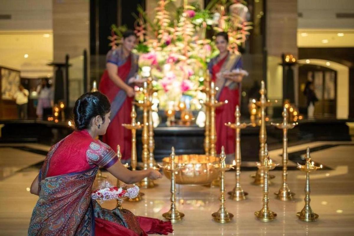 a woman standing in front of a altar with candles at Taj Lands End in Mumbai a woman standing in front of a altar with candles at Taj Lands End in Mumbai
