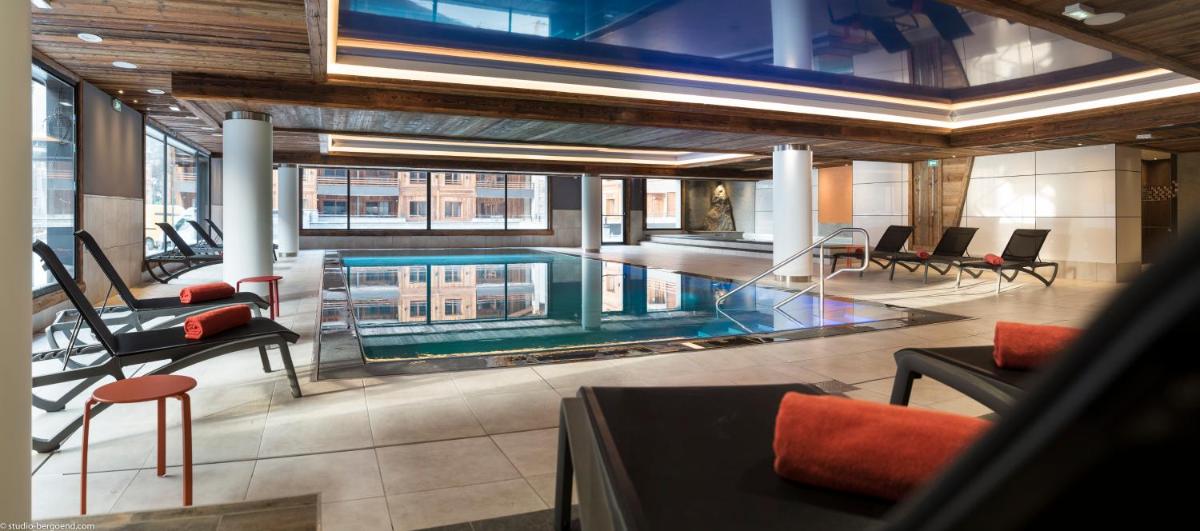 une piscine au milieu d'un bâtiment dans l'établissement MGM Hôtels & Résidences - Résidence Le Cristal de Jade, à Chamonix-Mont-Blanc