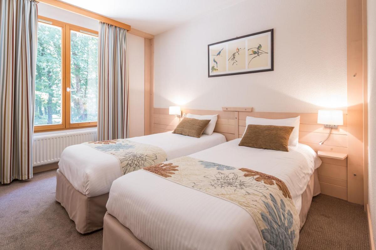Un ou plusieurs lits dans un hébergement de l'établissement Le Bois Dormant-Hôtel Restaurant & Spa Logis Hôtel