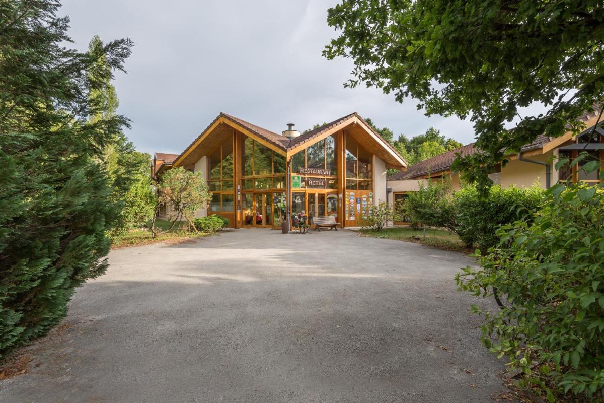 une grande maison avec beaucoup de fenêtres dans l'établissement Le Bois Dormant-Hôtel Restaurant & Spa Logis Hôtel, à Champagnole