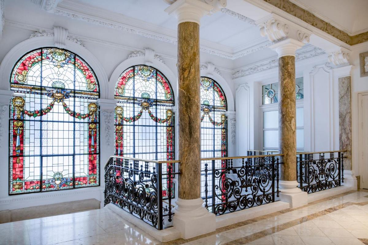 una habitación con dos columnas y vidrieras en Hotel Palacio del Retiro, Autograph Collection, en Madrid