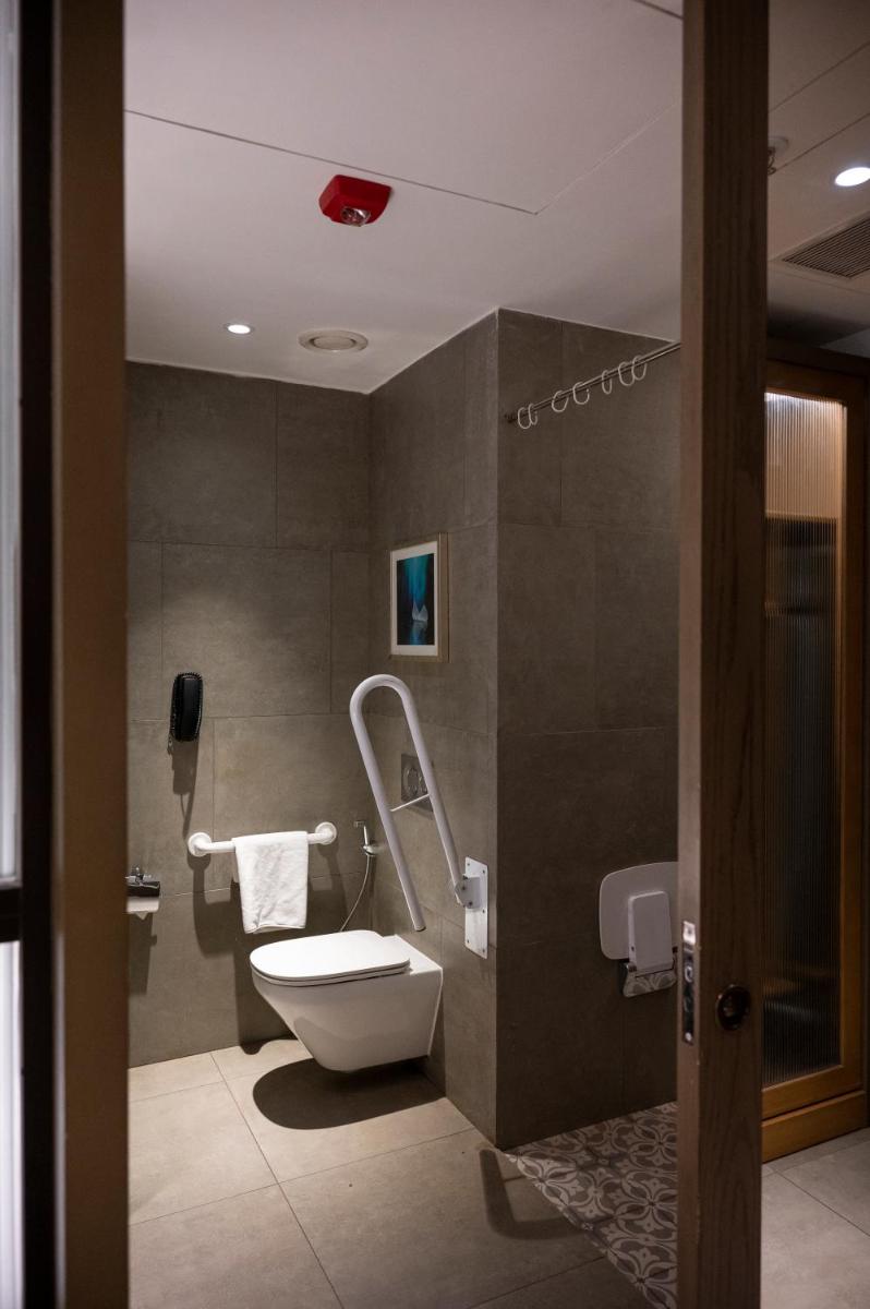 a bathroom with a toilet and a sink at Holiday Inn Goa Candolim in Candolim a bathroom with a toilet and a sink at Holiday Inn Goa Candolim in Candolim