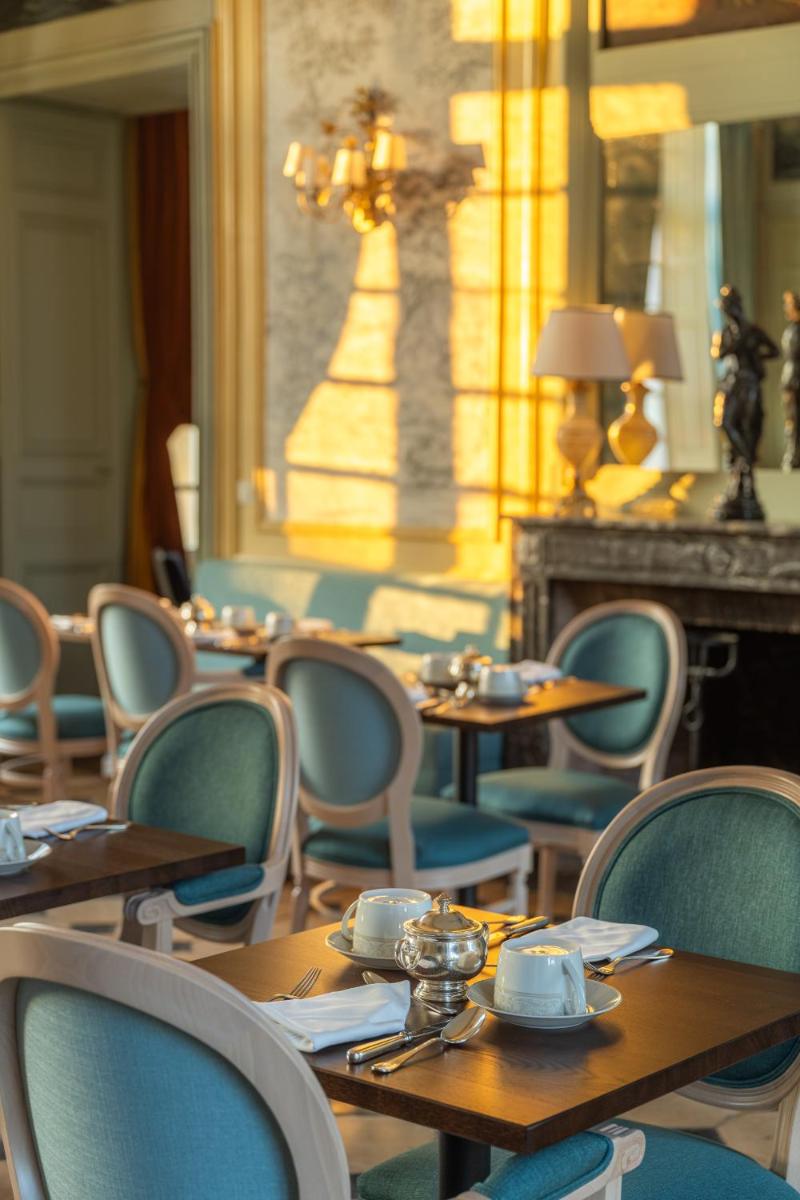 une salle à manger avec tables et chaises et un lustre dans l'établissement Le Château d'Etoges - Champagne, à Étoges