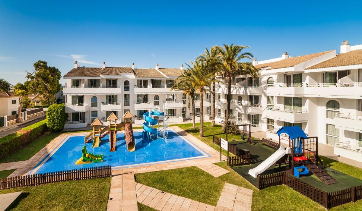 un edificio de apartamentos con piscina y tobogán de agua en Hoposa Hotel & Apartaments VillaConcha, en Puerto Pollensa