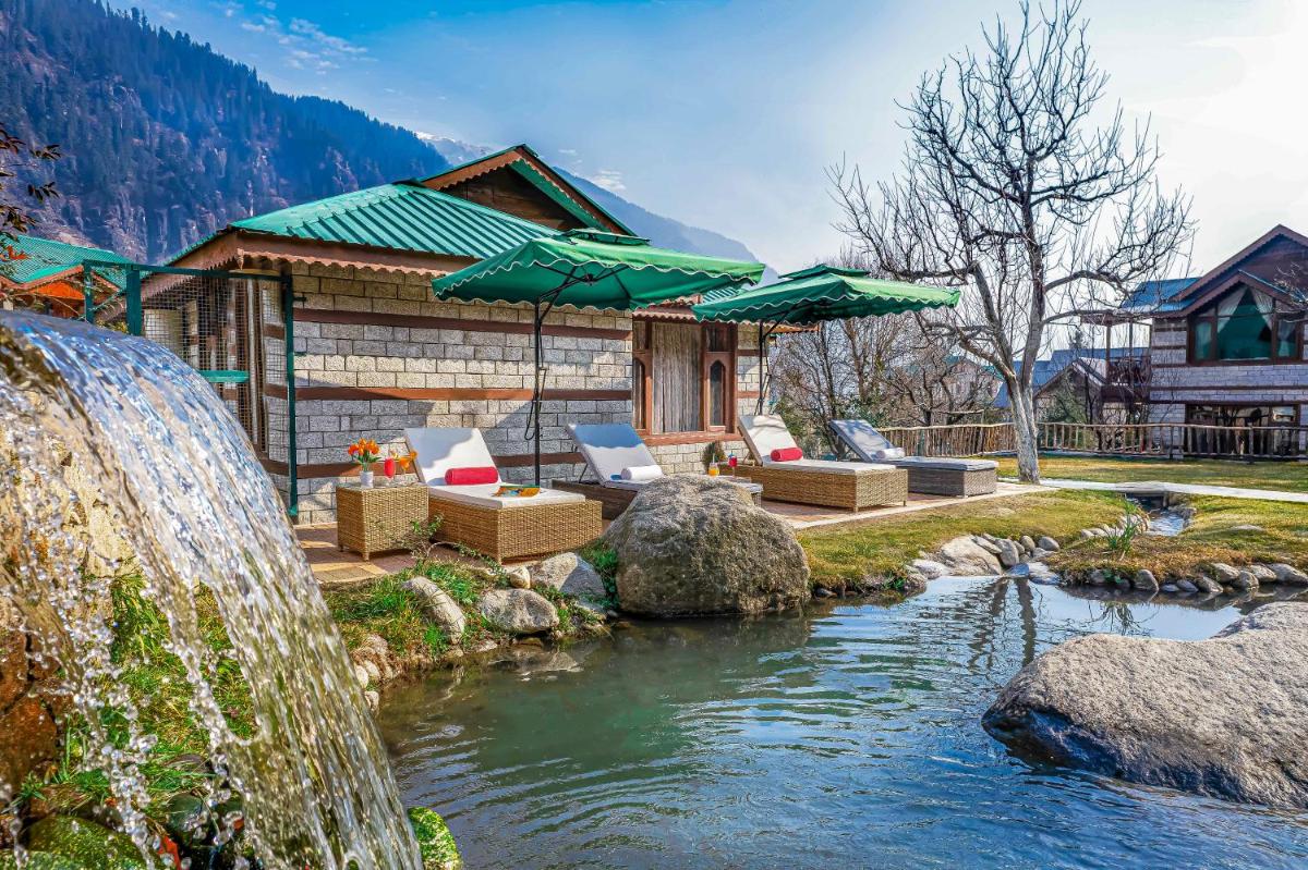 a house with a waterfall next to a river at Storii By ITC Hotels Urvashis Retreat, Manali in Manāli a house with a waterfall next to a river at Storii By ITC Hotels Urvashis Retreat, Manali in Manāli