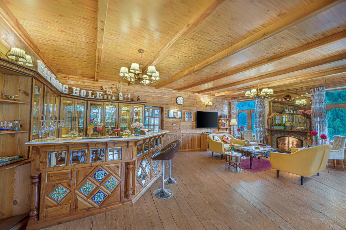 a large room with a bar and a living room at Storii By ITC Hotels Urvashis Retreat, Manali in Manāli a large room with a bar and a living room at Storii By ITC Hotels Urvashis Retreat, Manali in Manāli