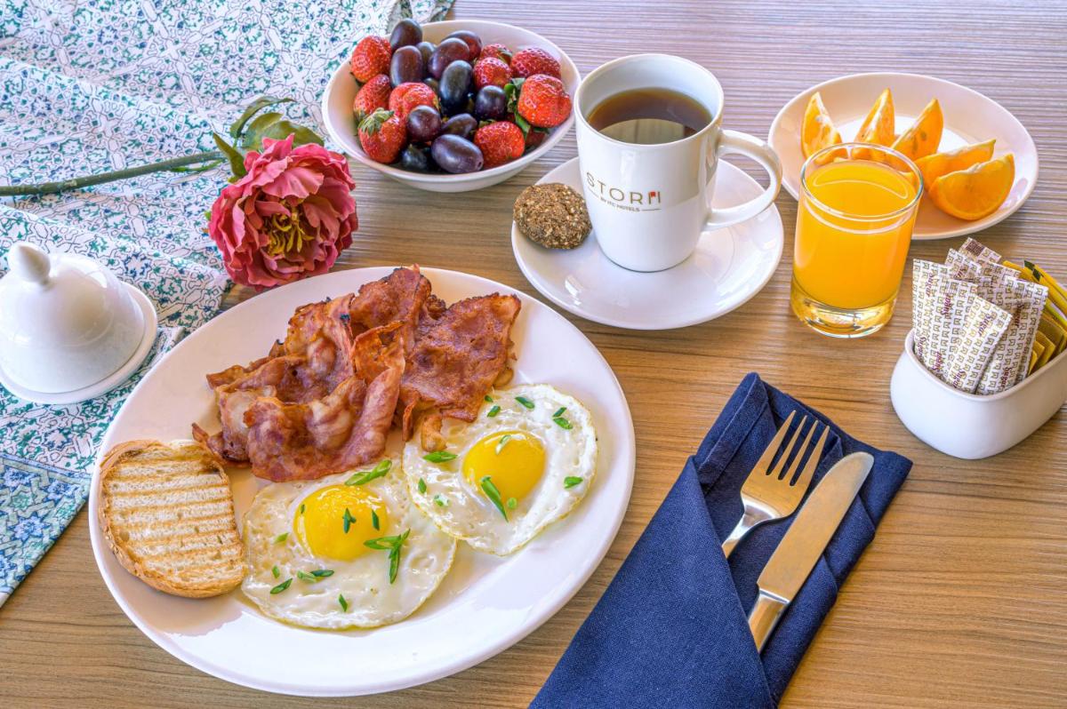 a table with a plate of eggs and bacon and a cup of coffee at Storii By ITC Hotels Urvashis Retreat, Manali in Manāli a table with a plate of eggs and bacon and a cup of coffee at Storii By ITC Hotels Urvashis Retreat, Manali in Manāli