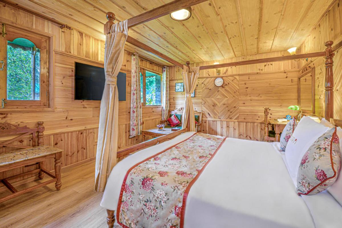 a bedroom with a bed in a wooden cabin at Storii By ITC Hotels Urvashis Retreat, Manali in Manāli a bedroom with a bed in a wooden cabin at Storii By ITC Hotels Urvashis Retreat, Manali in Manāli