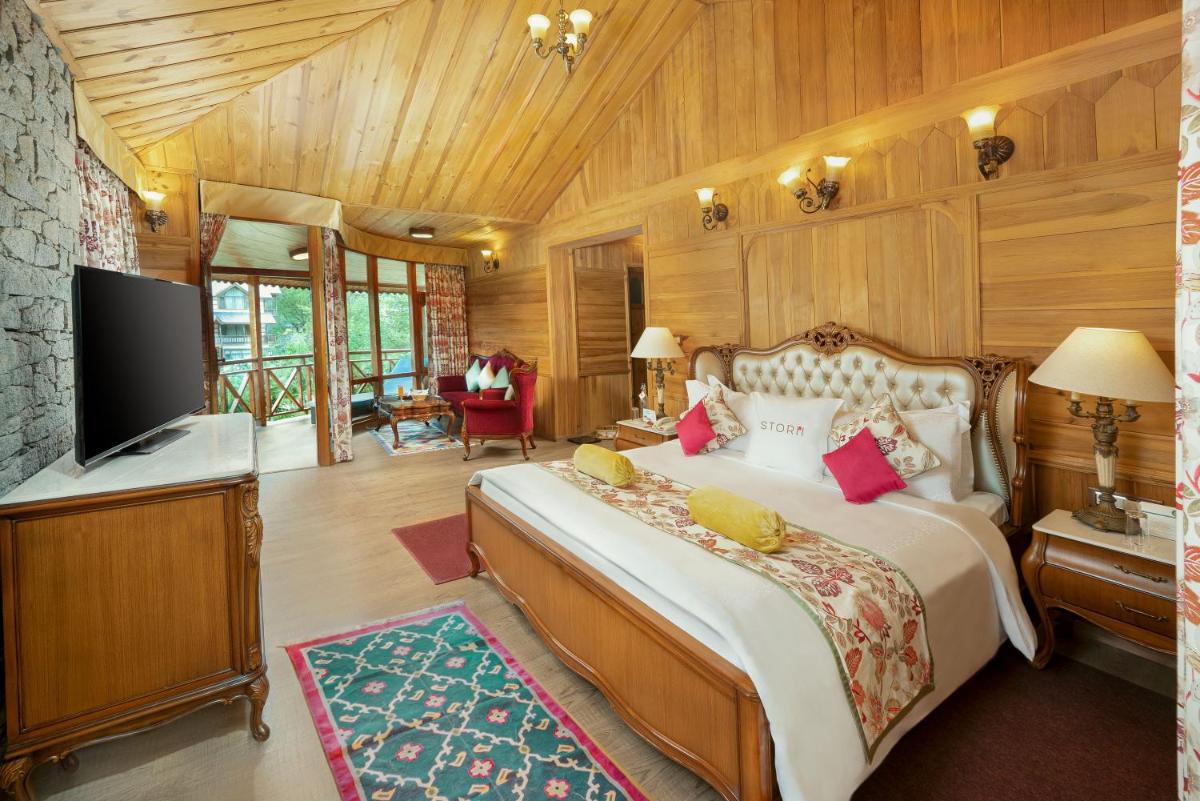 a bedroom with a large bed and a television at Storii By ITC Hotels Urvashis Retreat, Manali in Manāli a bedroom with a large bed and a television at Storii By ITC Hotels Urvashis Retreat, Manali in Manāli
