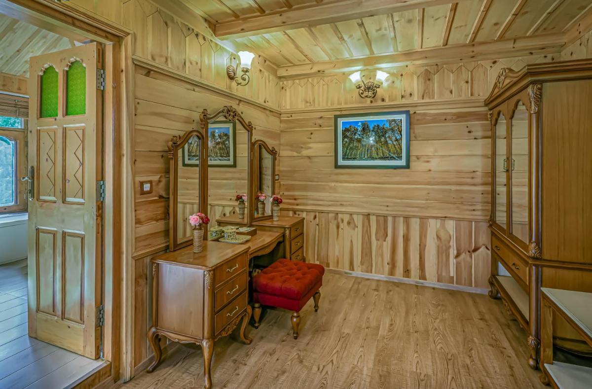 a wooden bathroom with a vanity and a red chair at Storii By ITC Hotels Urvashis Retreat, Manali in Manāli a wooden bathroom with a vanity and a red chair at Storii By ITC Hotels Urvashis Retreat, Manali in Manāli