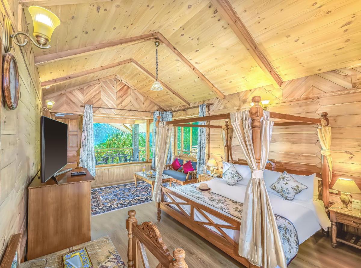 a log cabin bedroom with a bed and a tv at Storii By ITC Hotels Urvashis Retreat, Manali in Manāli a log cabin bedroom with a bed and a tv at Storii By ITC Hotels Urvashis Retreat, Manali in Manāli