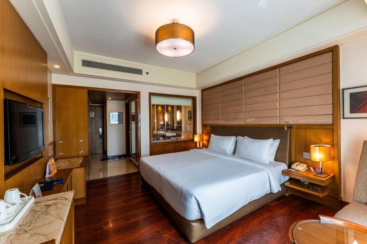 a hotel room with a bed and a television at Radisson Blu Hotel, Indore in Indore