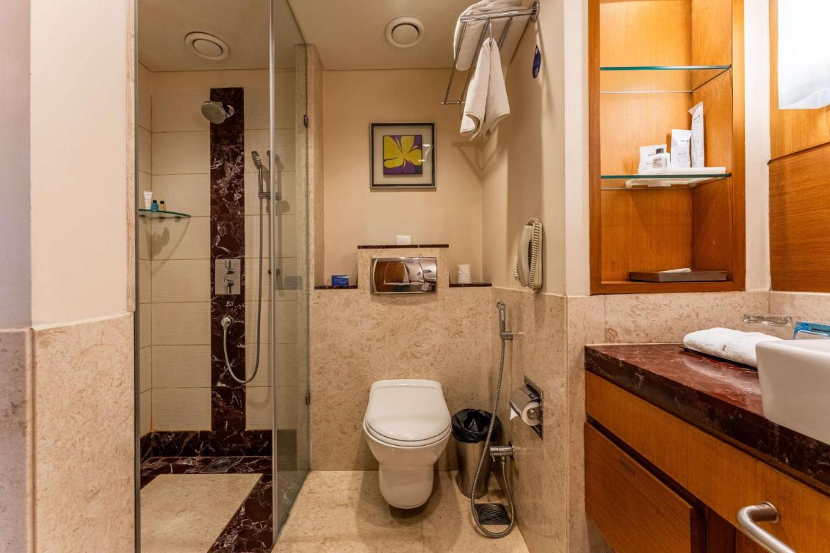 a bathroom with a shower and a toilet and a sink at Radisson Blu Hotel, Indore in Indore