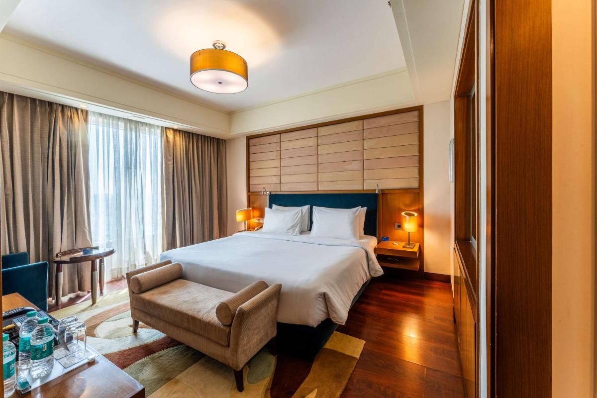 a hotel room with a bed and a chair at Radisson Blu Hotel, Indore in Indore