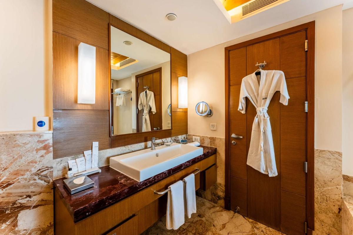 a bathroom with a sink and a large mirror at Radisson Blu Hotel, Indore in Indore