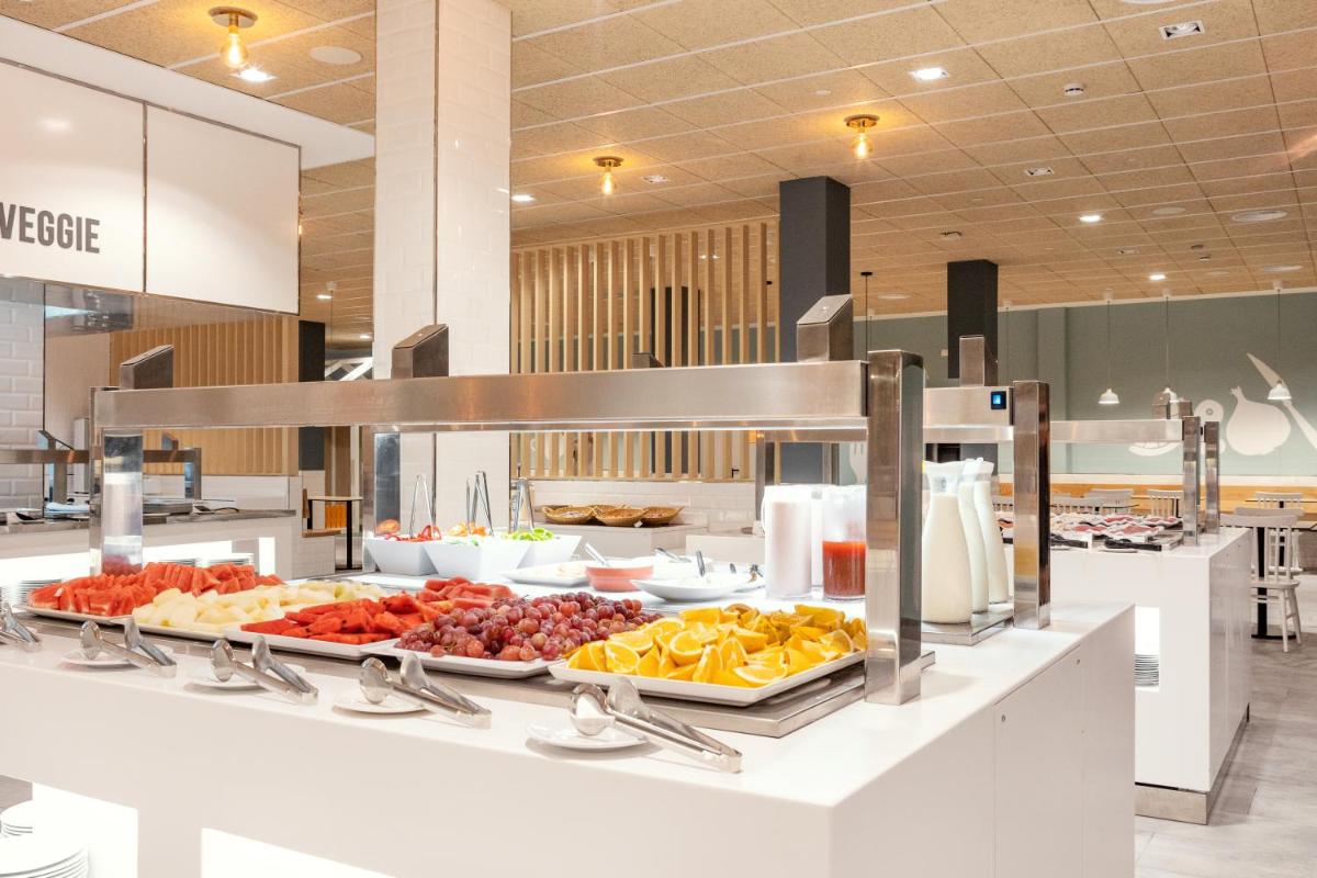 una línea de buffet con muchos tipos diferentes de fruta en Sunwing Fañabe Beach, en Adeje