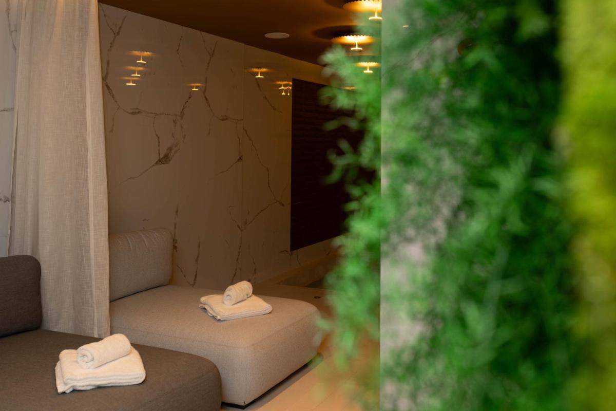Una habitación con dos toallas sentadas en un sofá. en Hotel Neptuno Playa & Spa, en Valencia 176 fotos más