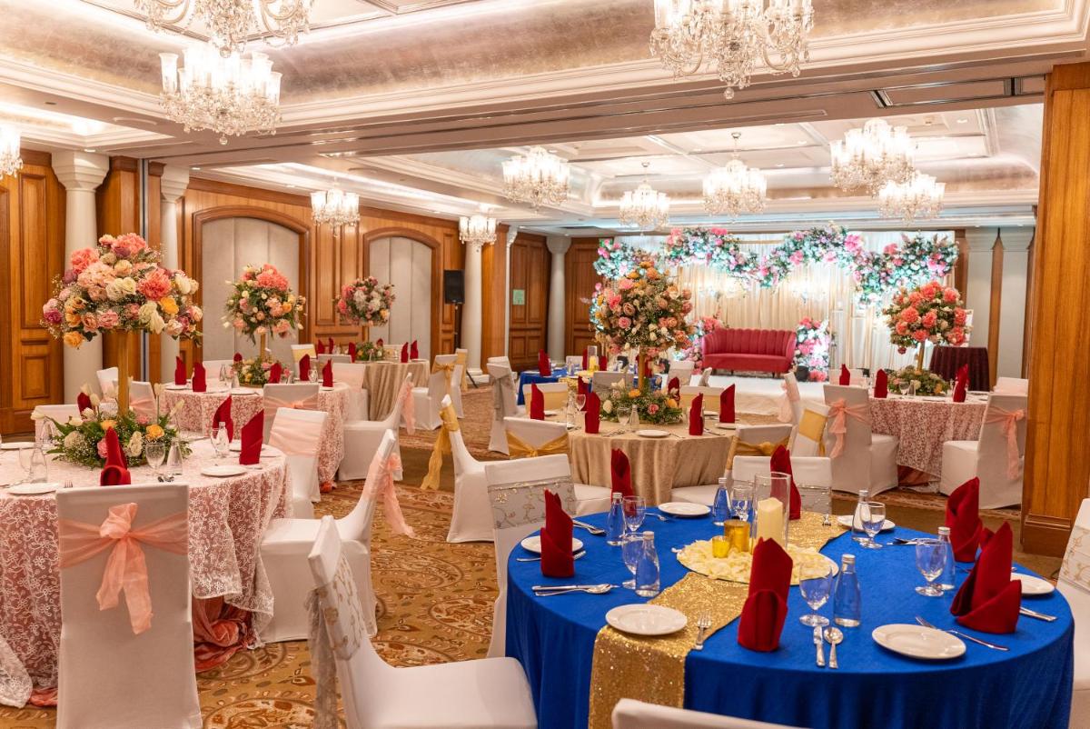 a banquet hall with tables and chairs and chandeliers at Hilton Mumbai International Airport Hotel in Mumbai