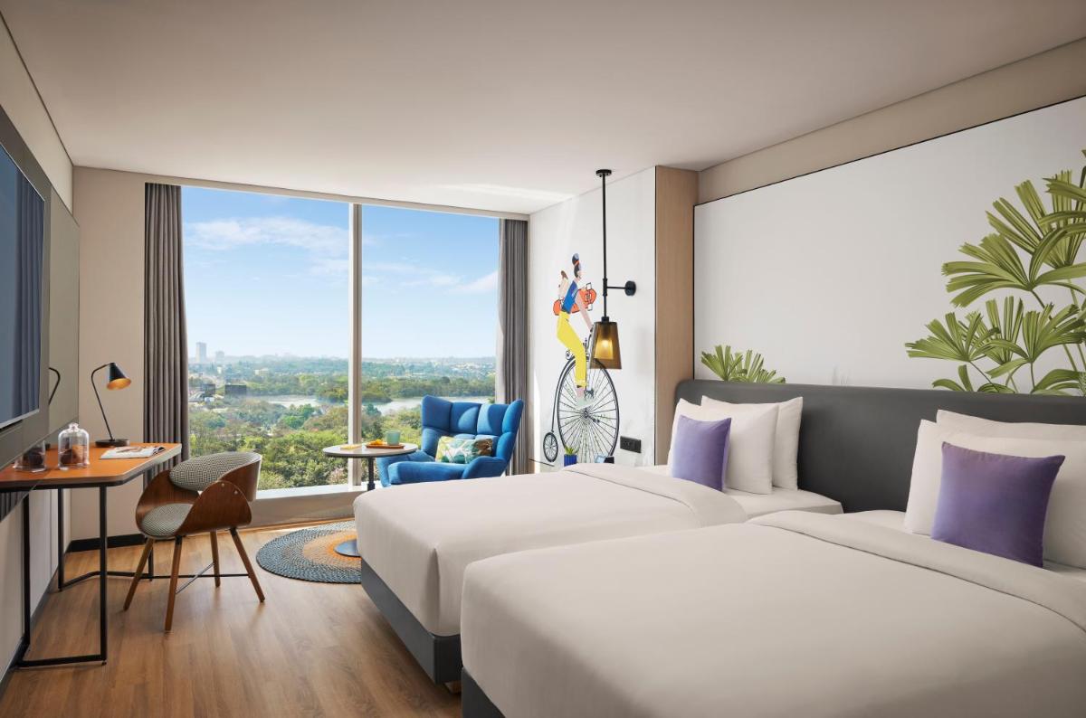 a hotel room with two beds and a large window at Hyatt Centric Hebbal Bengaluru in Bengaluru