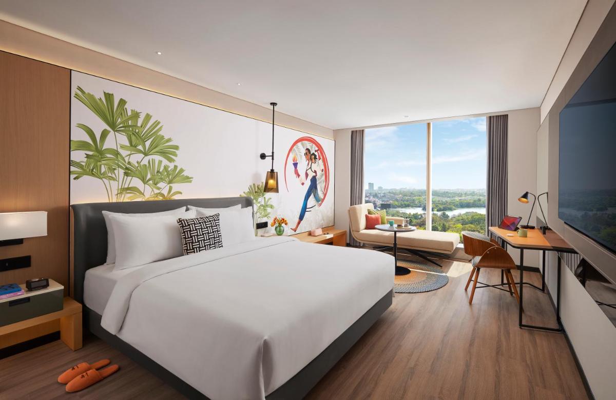 a bedroom with a large white bed and a desk at Hyatt Centric Hebbal Bengaluru in Bengaluru