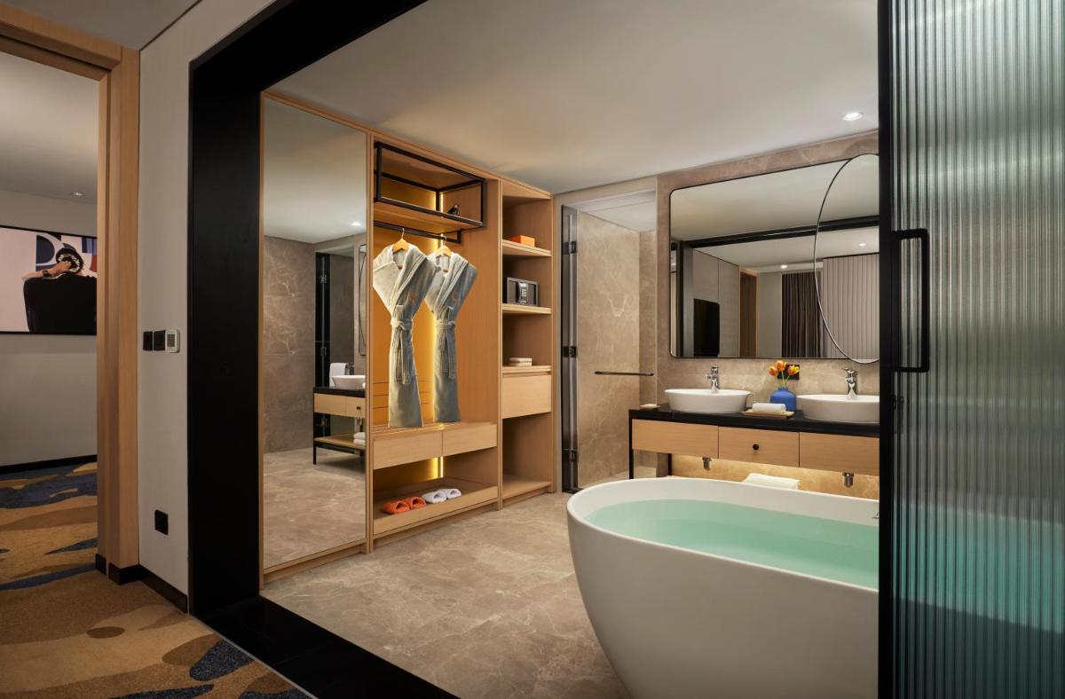 a bathroom with a tub and a sink at Hyatt Centric Hebbal Bengaluru in Bengaluru