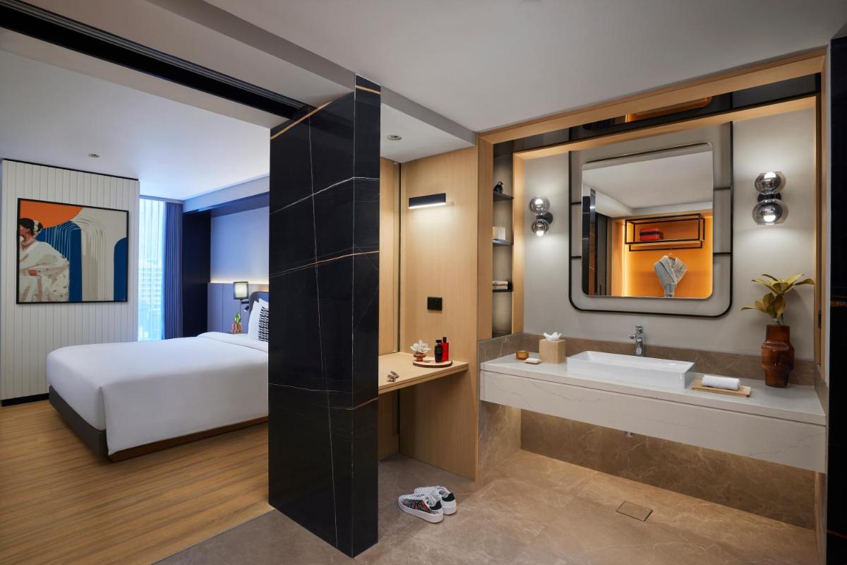 a bedroom with a bed and a bathroom with a sink at Hyatt Centric Hebbal Bengaluru in Bengaluru