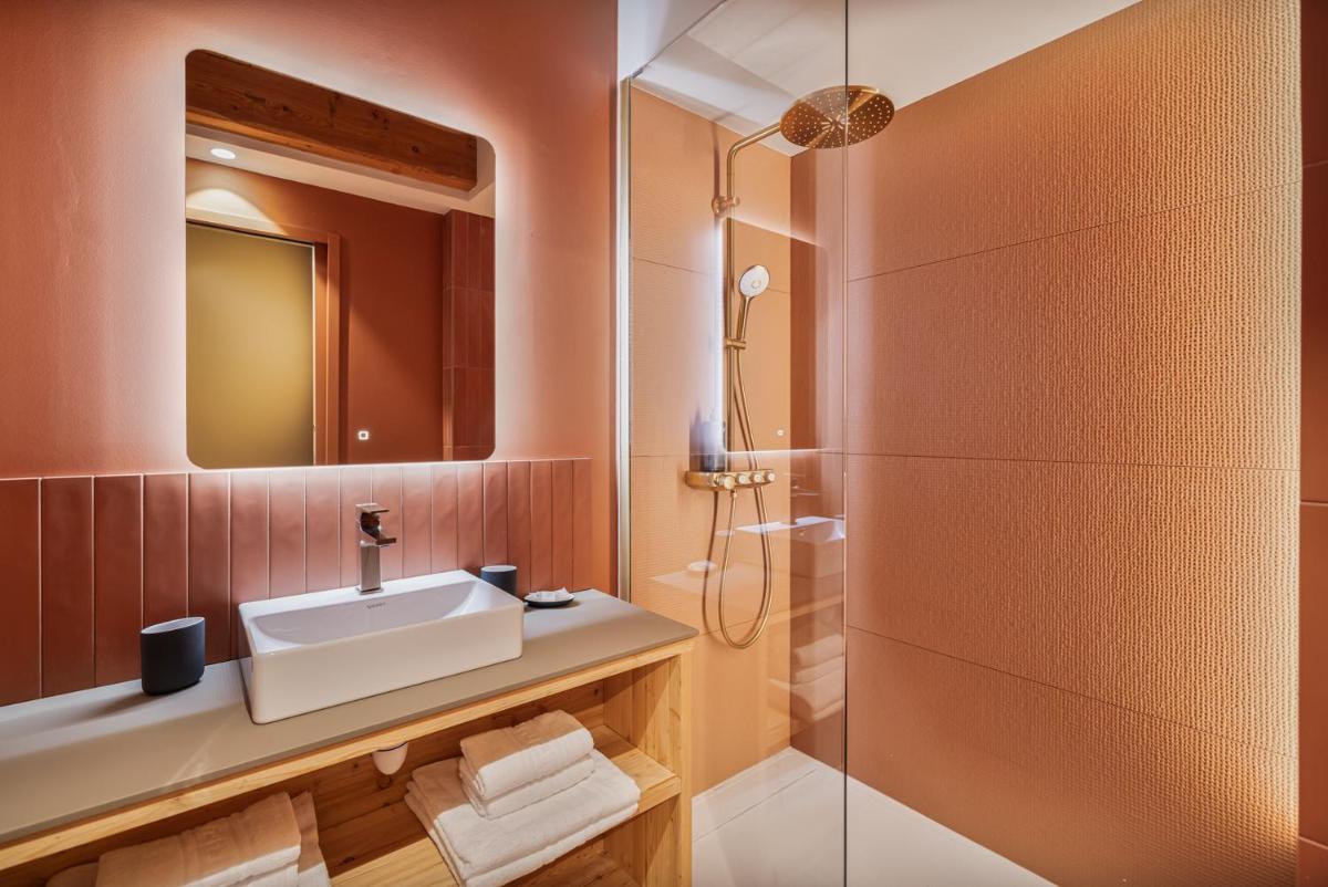 une salle de bain avec lavabo et douche dans l'établissement Alliey & Spa Piscine Appart-hôtel Serre chevalier, au Monêtier-les-Bains