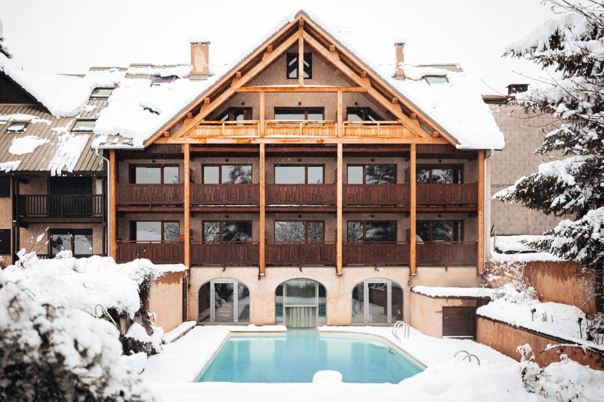 une maison avec piscine sous la neige dans l'établissement Alliey & Spa Piscine Appart-hôtel Serre chevalier, au Monêtier-les-Bains