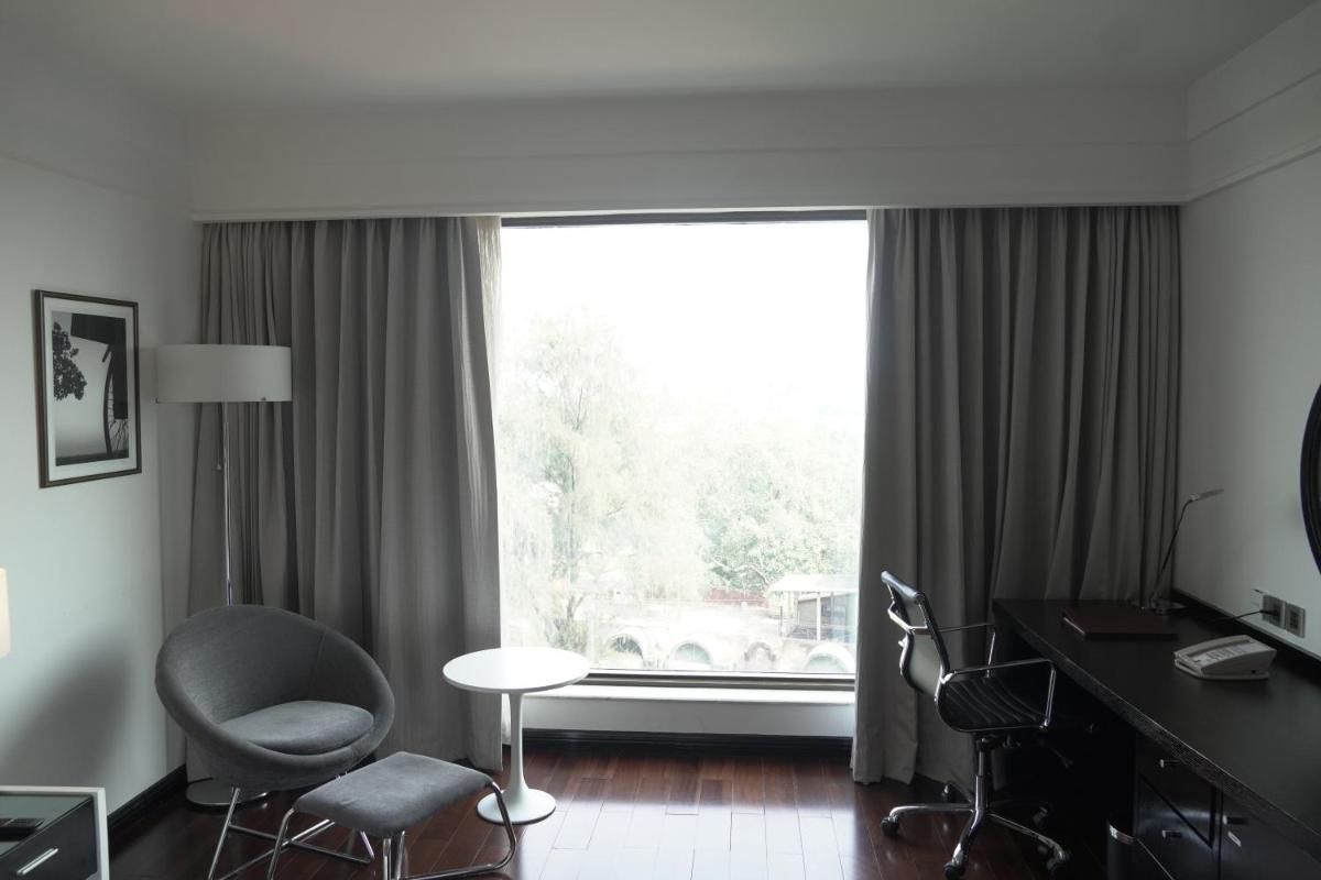 a room with a desk and chairs and a large window at Crowne Plaza Pune City Centre by IHG in Pune