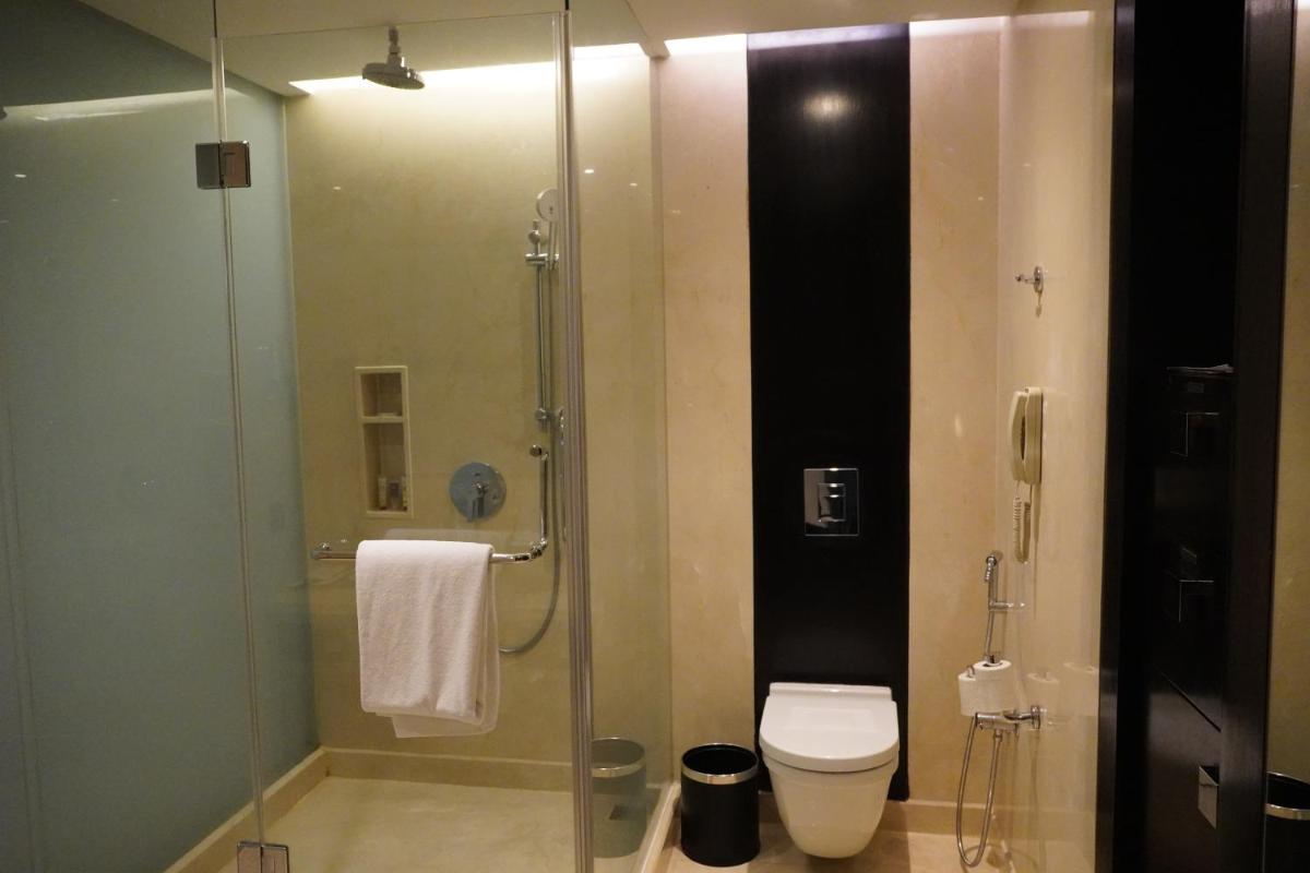 a bathroom with a glass shower with a toilet at Crowne Plaza Pune City Centre by IHG in Pune