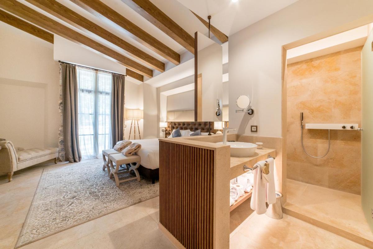 Un baño con una cama y un lavabo en una habitación. en Hotel Creu de Tau Art&Spa-Adults only, en Capdepera