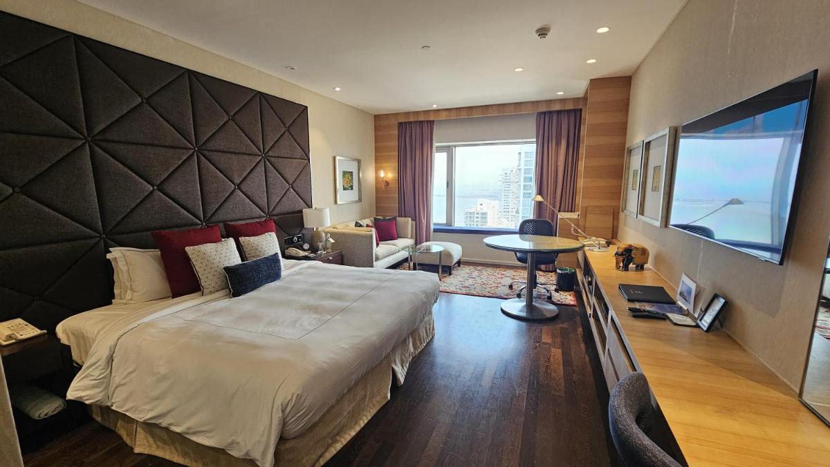 a hotel room with a large bed and a television at Taj Lands End in Mumbai a hotel room with a large bed and a television at Taj Lands End in Mumbai