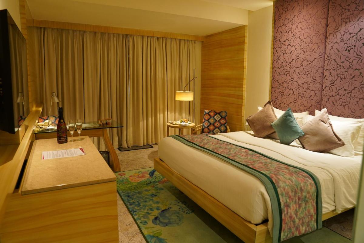 a hotel room with a bed and a desk at Hotel Royal Orchid Jaipur, Tonk Road in Jaipur