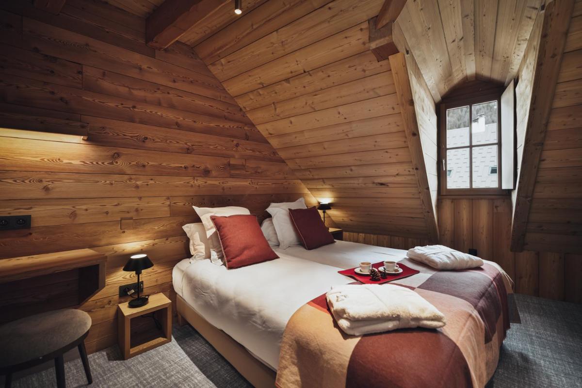 une chambre avec un lit dans une cabane en bois dans l'établissement Alliey & Spa Piscine Appart-hôtel Serre chevalier, au Monêtier-les-Bains 93 autres photos