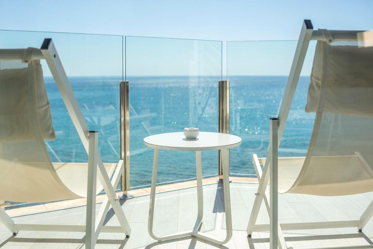 una mesa blanca y sillas frente a una ventana en Melbeach Hotel & Spa - Adults Only, en Canyamel