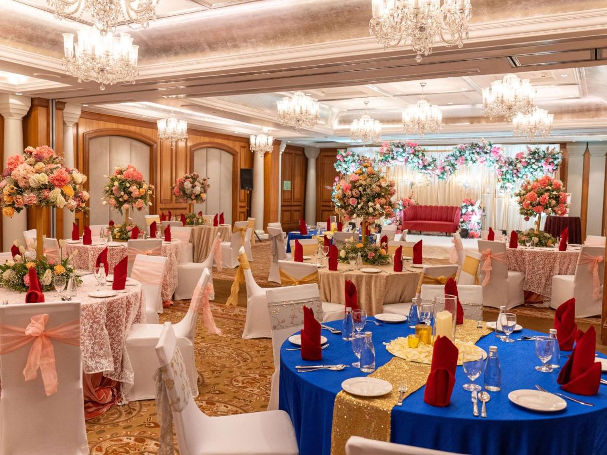 a banquet hall with tables and chairs and chandeliers at Hilton Mumbai International Airport Hotel in Mumbai