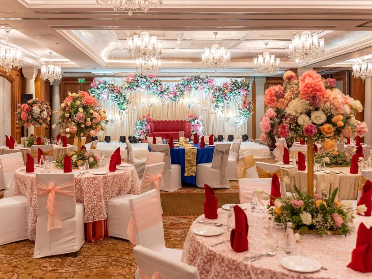 a banquet hall with white tables and chairs and flowers at Hilton Mumbai International Airport Hotel in Mumbai