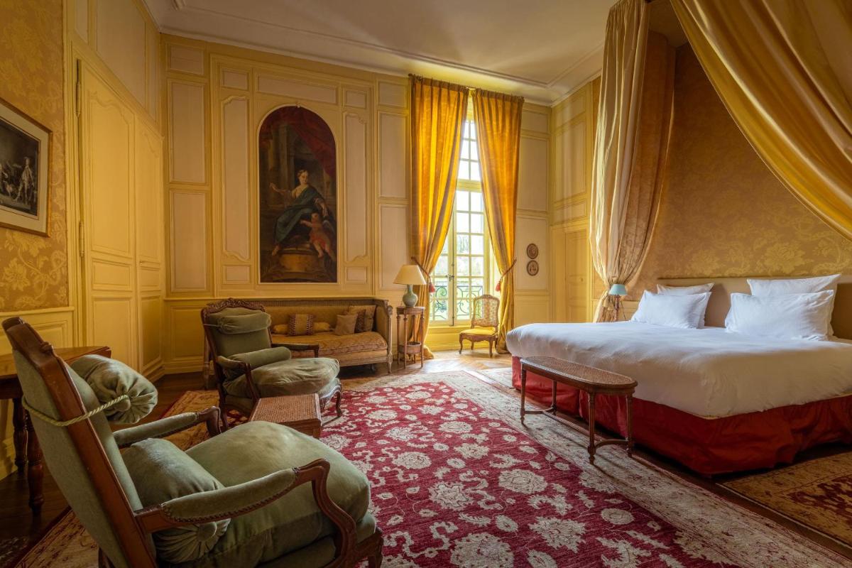 une chambre avec un lit, des chaises et une fenêtre dans l'établissement Le Château d'Etoges - Champagne, à Étoges
