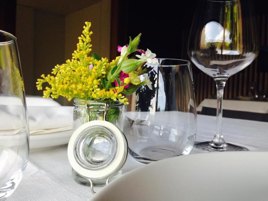 una mesa con vasos y un jarrón de flores. en Hotel Terra Bonansa, en Bonansa 40 fotos más