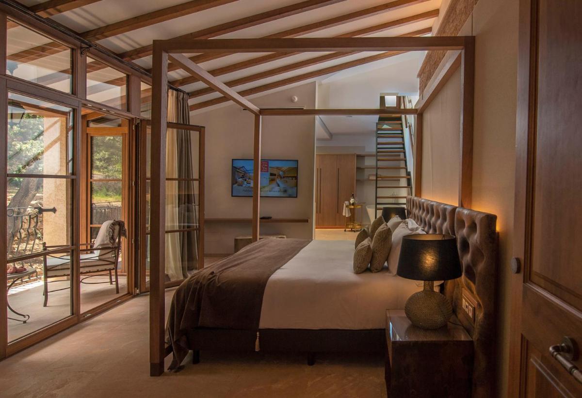 Un dormitorio con una cama grande y una escalera. en Hotel Creu de Tau Art&Spa-Adults only, en Capdepera